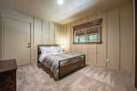 This cozy bedroom features a comfortable queen-size bed with a nature-inspired duvet cover, perfect for a restful night's sleep.