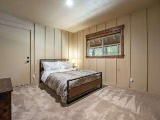This cozy bedroom features a comfortable queen-size bed with a nature-inspired duvet cover, perfect for a restful night's sleep.