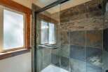 Experience a spa-like retreat in this bathroom featuring a luxurious glass-enclosed shower with striking slate tile accents.