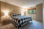 Experience cozy comfort in this charming bedroom, featuring a king-sized bed with a classic black and white buffalo check quilt.