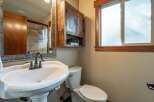 This charming bathroom features a pedestal sink with a vintage-inspired faucet, complemented by a rustic wooden medicine cabinet.