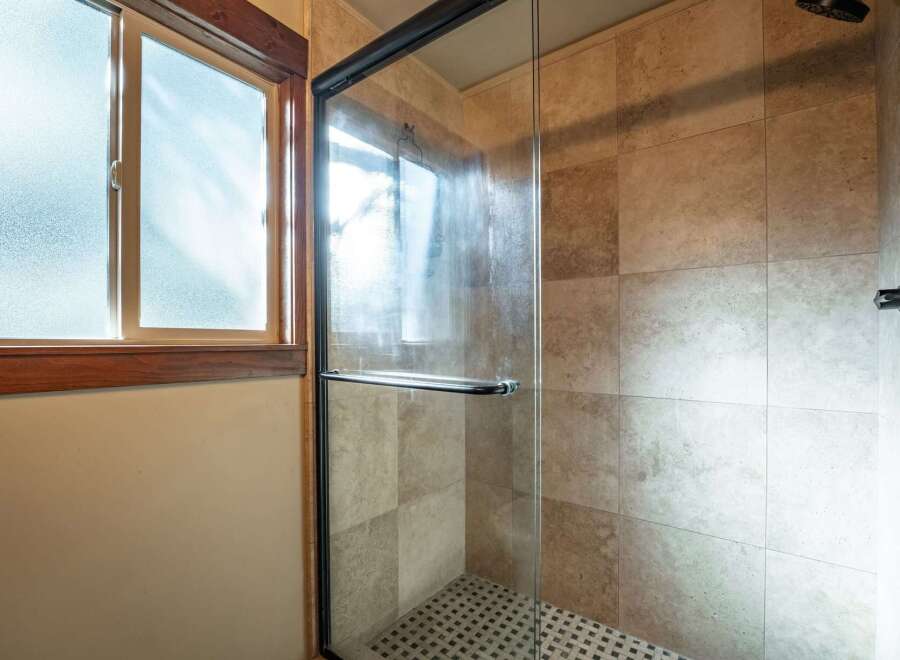 Step into this beautifully appointed bathroom featuring a spacious glass-enclosed shower with elegant tilework.