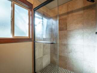 Step into this beautifully appointed bathroom featuring a spacious glass-enclosed shower with elegant tilework.