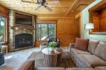 Experience rustic charm in this cozy living room, featuring a stunning stone fireplace and a mounted television perfect for movie nights.