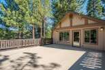 Enjoy the serene mountain lifestyle with this spacious deck, perfect for outdoor entertaining or simply relaxing amidst the towering pine trees.
