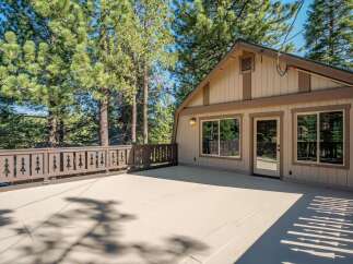Enjoy the serene mountain lifestyle with this spacious deck, perfect for outdoor entertaining or simply relaxing amidst the towering pine trees.
