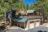 Nestled among tall pine trees, this charming mountain home offers a unique A-frame design with a durable metal roof.