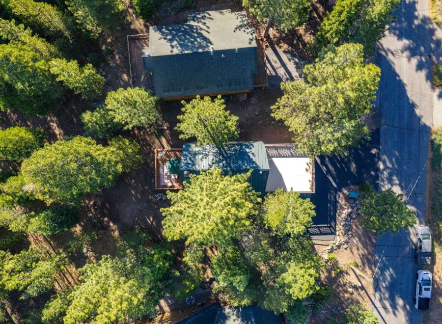 Discover this charming cabin nestled among tall pine trees, offering a serene mountain retreat.