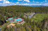 Discover this stunning mountain resort featuring multiple swimming pools, a playground, and a golf course, all nestled within a dense pine forest.