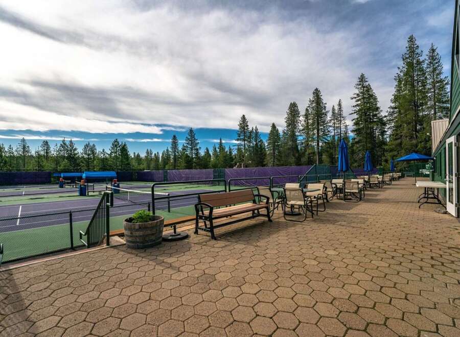 Enjoy a game of tennis on these pristine courts, surrounded by the serene beauty of tall pine trees.