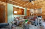 Experience rustic charm in this inviting living space, featuring a comfortable sectional sofa centered around a unique distressed wood coffee table.
