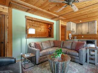 Experience rustic charm in this inviting living space, featuring a comfortable sectional sofa centered around a unique distressed wood coffee table.