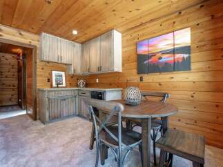 Experience cozy living in this charming cabin-style room, featuring warm wood-paneled walls and ceiling.