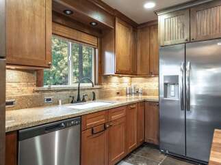 This kitchen boasts beautiful wooden cabinetry and granite countertops, creating a warm and inviting atmosphere.