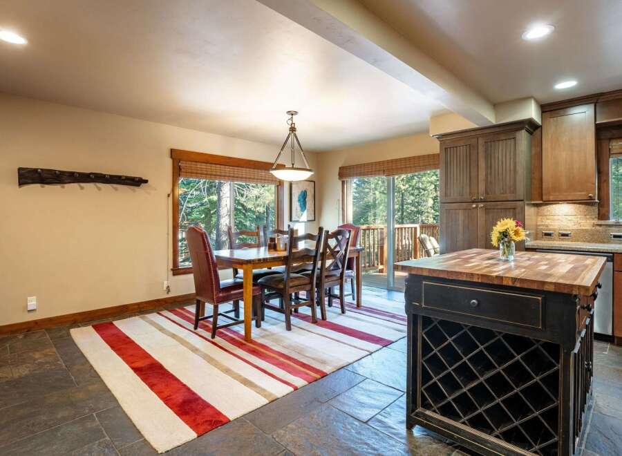 Experience rustic charm in this inviting dining area, featuring a sturdy wooden table with plush leather chairs perfect for family gatherings.