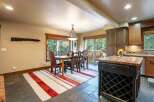 Experience rustic charm in this inviting dining area, featuring a sturdy wooden table with plush leather chairs perfect for family gatherings.