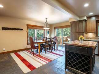 Experience rustic charm in this inviting dining area, featuring a sturdy wooden table with plush leather chairs perfect for family gatherings.