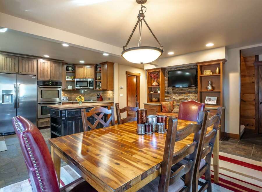 This spacious dining area seamlessly integrates with a modern kitchen, featuring stainless steel appliances and ample cabinetry.