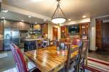 This spacious dining area seamlessly integrates with a modern kitchen, featuring stainless steel appliances and ample cabinetry.