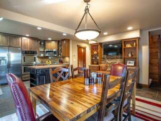 This spacious dining area seamlessly integrates with a modern kitchen, featuring stainless steel appliances and ample cabinetry.