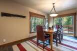 Experience rustic charm in this inviting dining room, featuring a sturdy wooden table surrounded by comfortable leather and plaid chairs.