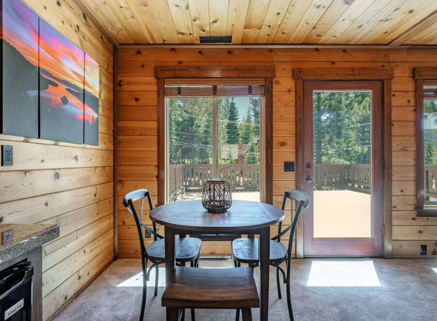 Experience cozy cabin living with this charming dining area, featuring a rustic wooden table and chairs perfect for intimate meals.