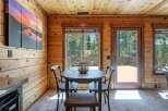Experience cozy cabin living with this charming dining area, featuring a rustic wooden table and chairs perfect for intimate meals.