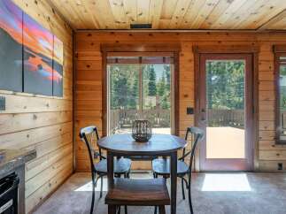 Experience cozy cabin living with this charming dining area, featuring a rustic wooden table and chairs perfect for intimate meals.