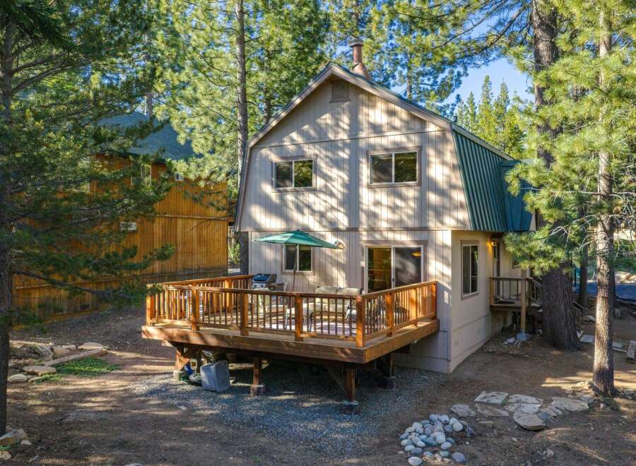 Enjoy outdoor living on this spacious wooden deck, complete with a grill and seating area, perfect for entertaining.