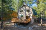 Enjoy outdoor living on this spacious wooden deck, complete with a grill and seating area, perfect for entertaining.