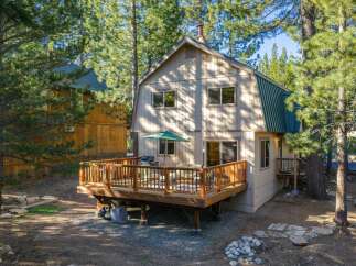 Enjoy outdoor living on this spacious wooden deck, complete with a grill and seating area, perfect for entertaining.
