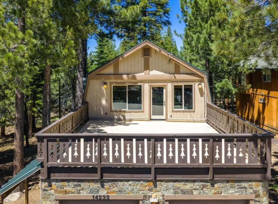 Experience mountain living in this charming cabin featuring a spacious deck perfect for enjoying the surrounding pine trees.