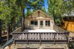 Experience mountain living in this charming cabin featuring a spacious deck perfect for enjoying the surrounding pine trees.