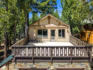 Experience mountain living in this charming cabin featuring a spacious deck perfect for enjoying the surrounding pine trees.