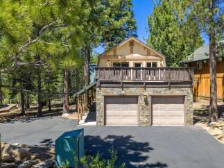 Discover this charming mountain home featuring a spacious upper-level deck perfect for enjoying the surrounding pine forest views.