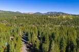 Nestled amidst a dense forest of towering pine trees, this property offers a serene mountain retreat.
