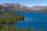 Experience the ultimate lakeside lifestyle with this stunning property offering breathtaking views of a pristine blue lake surrounded by lush green forests and majestic mountains.