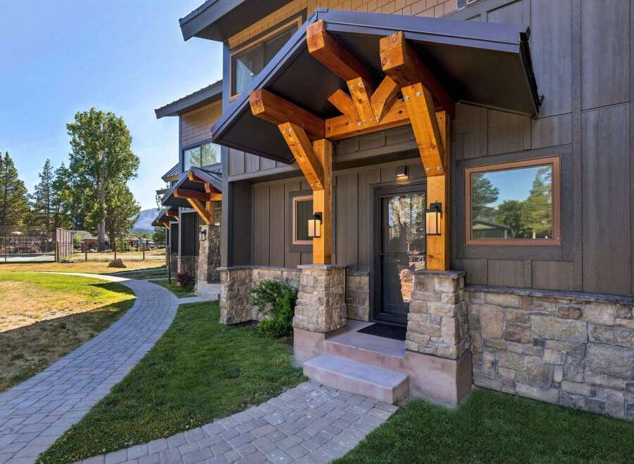 Experience modern mountain living with this stunning property featuring a stone and wood exterior.