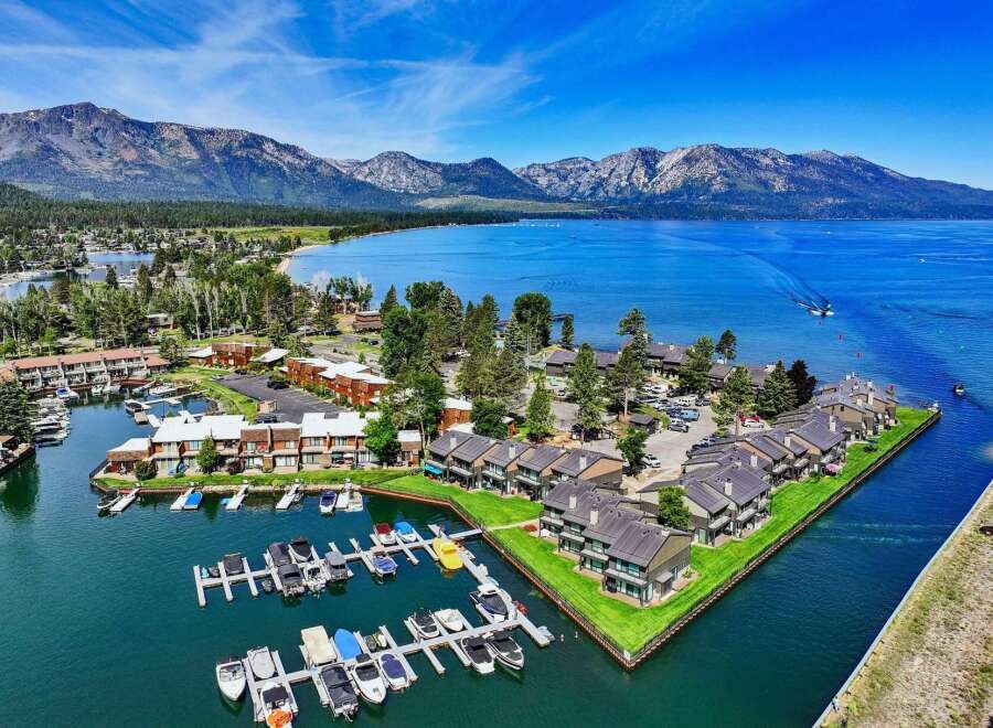 Experience luxury living with this stunning aerial view of a waterfront property featuring a private marina and modern townhomes.
