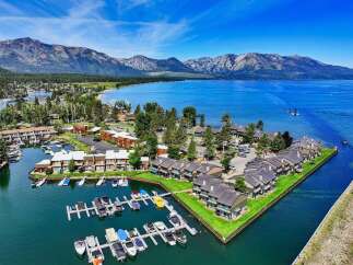 Experience luxury living with this stunning aerial view of a waterfront property featuring a private marina and modern townhomes.