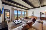 Experience breathtaking lake views from this stunning living room, featuring a spacious sectional sofa perfect for relaxation.