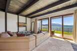 Experience breathtaking lake and mountain views from this stunning living room, featuring a plush sectional sofa perfect for relaxation.