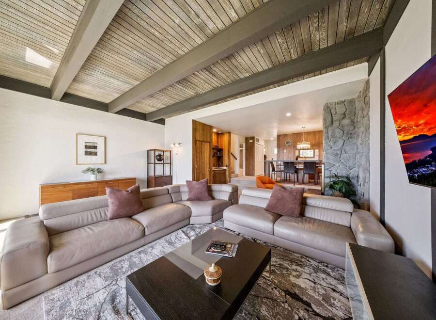 Experience modern living in this spacious living room featuring a large sectional sofa and a striking stone fireplace.