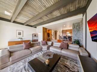 Experience modern living in this spacious living room featuring a large sectional sofa and a striking stone fireplace.