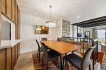Experience elegant dining with this stylish wooden table, perfectly complemented by modern upholstered chairs.