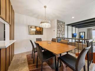 Experience elegant dining with this stylish wooden table, perfectly complemented by modern upholstered chairs.