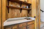 Discover a charming wet bar area featuring a stainless steel sink and elegant quartz countertops, perfect for entertaining.