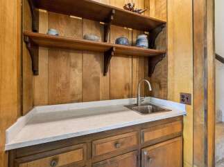 Discover a charming wet bar area featuring a stainless steel sink and elegant quartz countertops, perfect for entertaining.