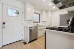 Discover this charming kitchen featuring crisp white cabinetry and sleek stainless steel appliances, including a dishwasher and a gas range.
