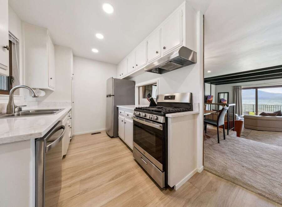 Discover this charming kitchen featuring sleek stainless steel appliances, including a modern gas range and a dishwasher.